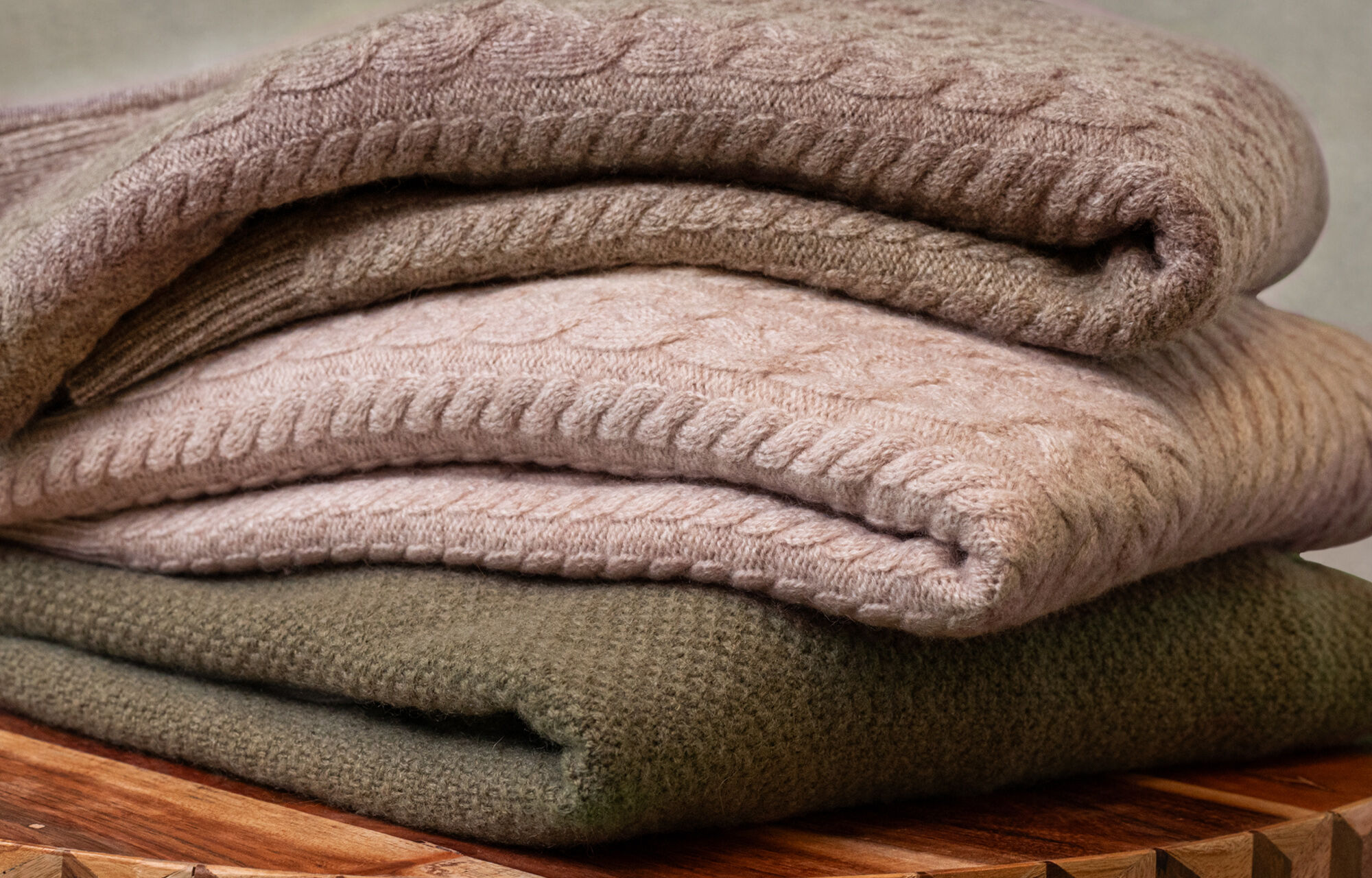 Stack of Men's Sweaters. Bolzano Raglan Turtleneck Sweater in Olive and Aalborg Cable Quarter Zip Cashmere Sweater in Light Brown Heather